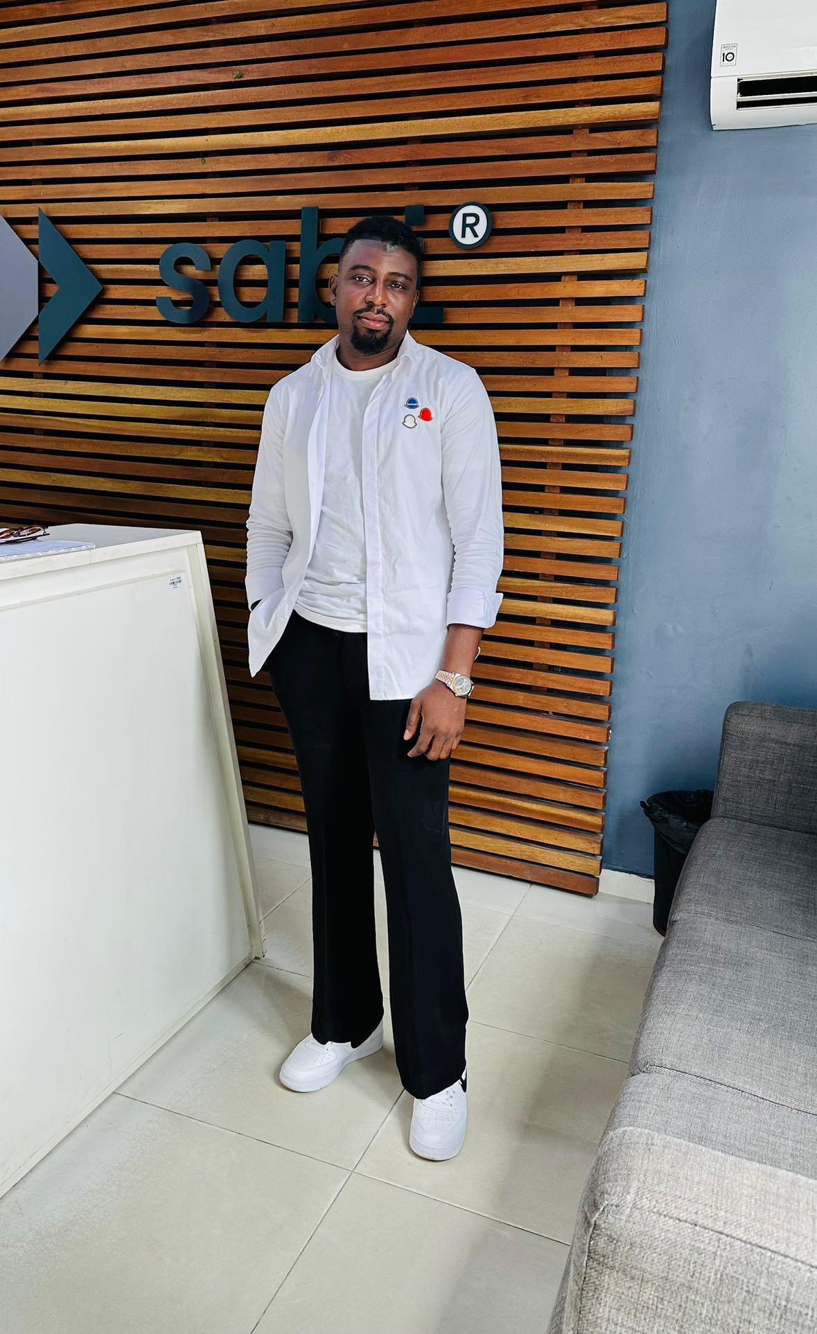 Desmond standing in front of a wooden wall at the Sabi office